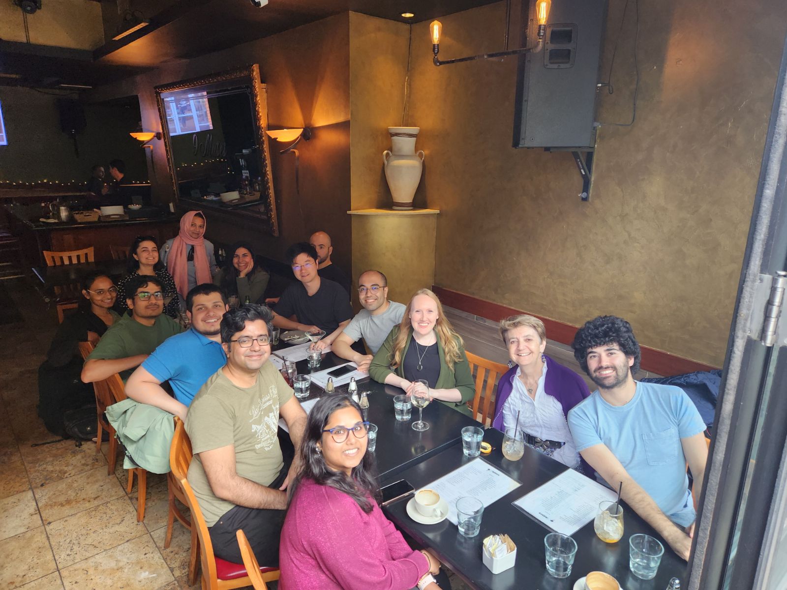 Lab members sitting at a table at a restaurant and smiling.