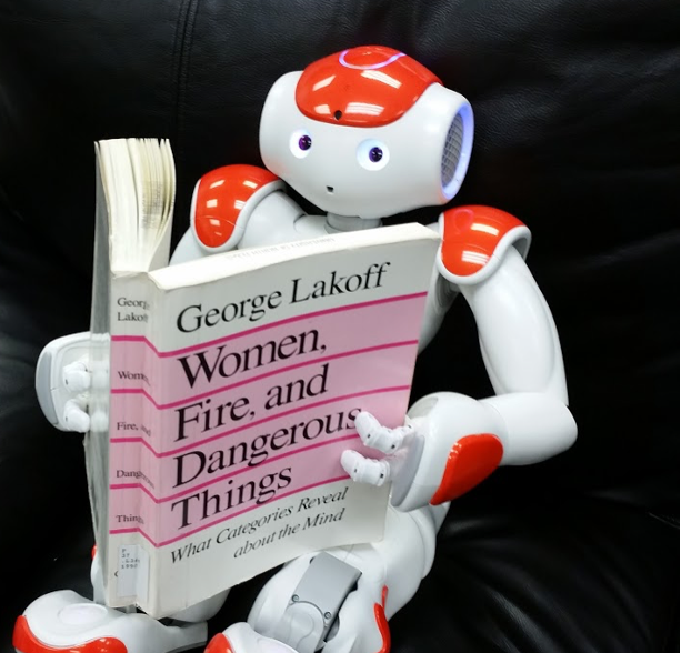 A robot sitting on a couch, reading a book.